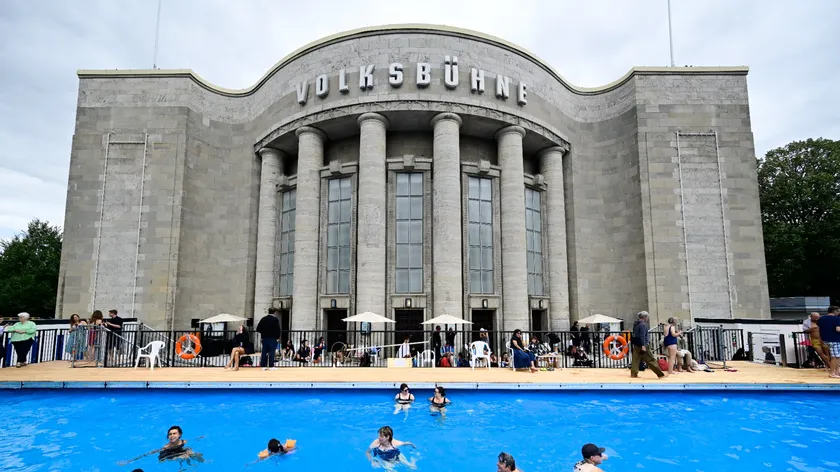 Des-visiteurs-se-baignent-dans-la-piscine-dite-Volksbad-installee-devant-le-theatre-Volksbuehne-sur-la-place-Rosa-Luxemburg-Platz-a-Berlin-le-7-aout-2026-jour-de-son-inauguration-2332367